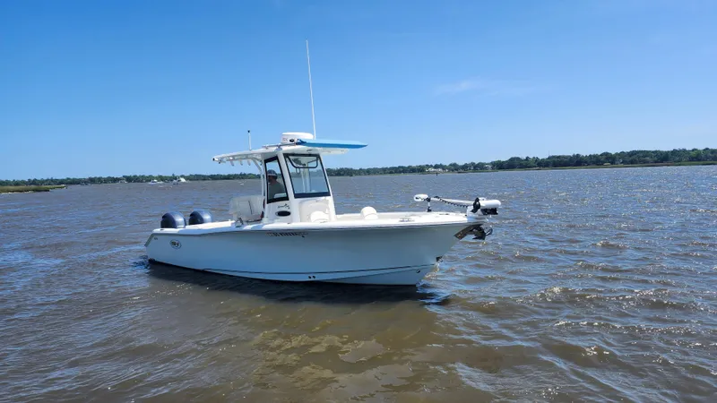 Slide: The Image of 2022 Sea Hunt Gamefish 25 boat on calm water under clear blue sky. - 25