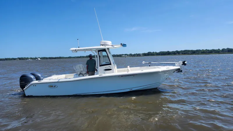 Slide: The Image of 2022 Sea Hunt Gamefish 25 boat on water, side view, clear sky. - 26