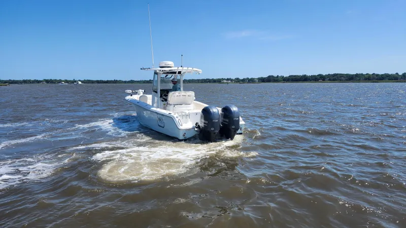 Slide: The Image of 2022 Sea Hunt Gamefish 25 boat cruising on a sunny day in open water. - 29