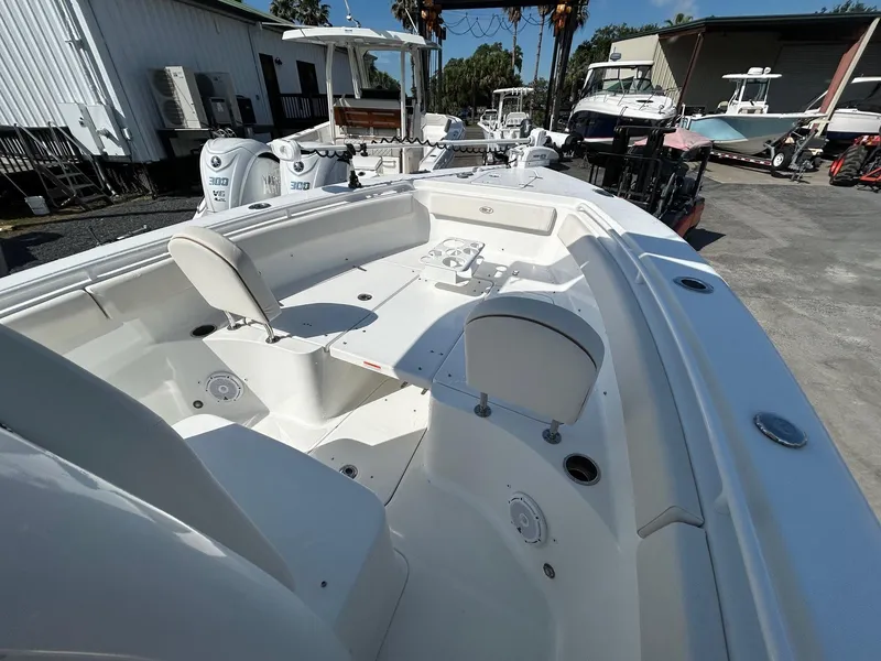 Slide: The Image of 2022 Sea Hunt Gamefish 25 boat interior with seating and storage, docked outdoors. - 3