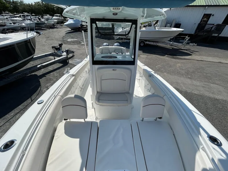 Slide: The Image of 2022 Sea Hunt Gamefish 25 boat interior with seating and console, docked outdoors. - 4