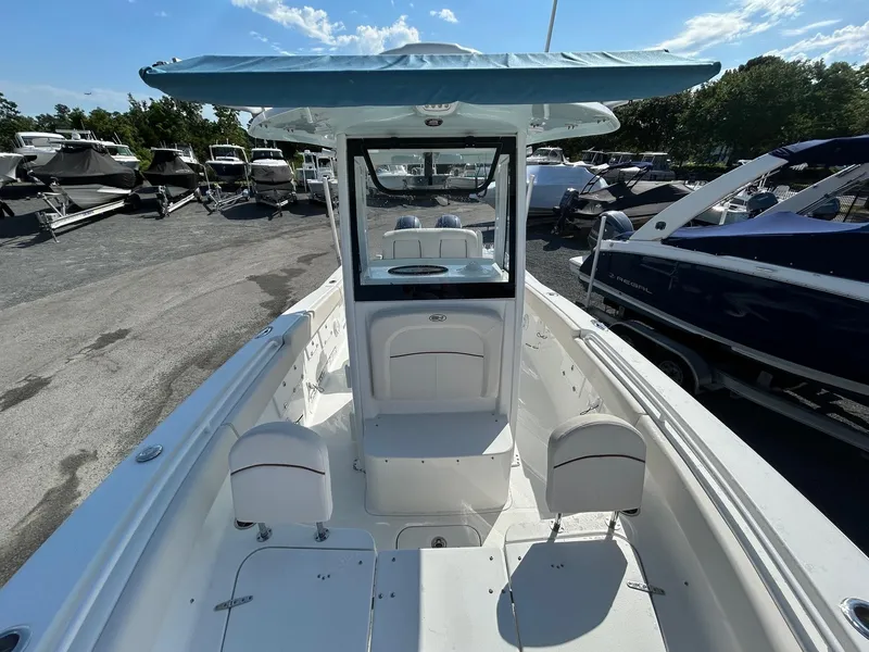 Slide: The Image of 2022 Sea Hunt Gamefish 25 boat with blue canopy, docked among other boats. - 5