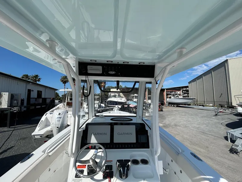 Slide: The Image of 2022 Sea Hunt Gamefish 25 boat console with Garmin displays in a marina setting. - 9