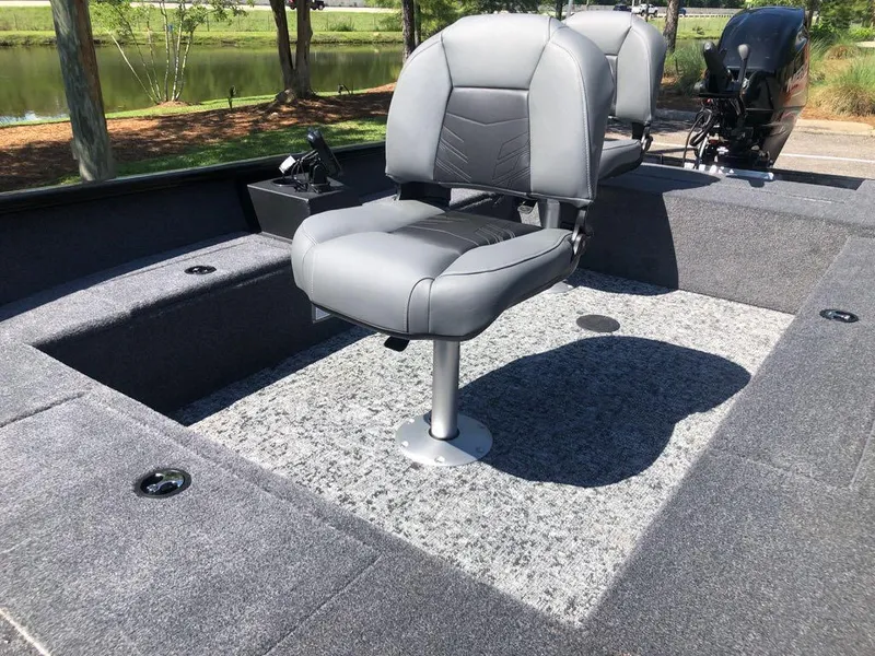 Slide: The Image of 2025 Tracker Super Guide V-16 T boat interior with gray seating and carpeted deck. - 10