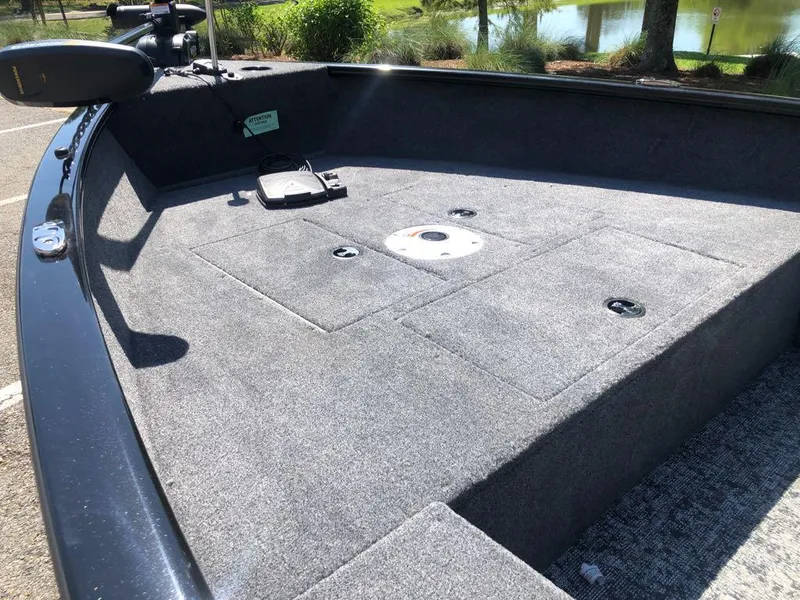 Slide: The Image of 2025 Tracker Super Guide V-16 T boat deck with carpeted surface and storage compartments. - 9