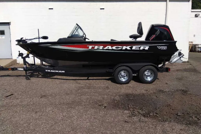 The Image of 2025 Tracker Targa V-18 WT boat on trailer, black with red accents, parked outdoors. - 0