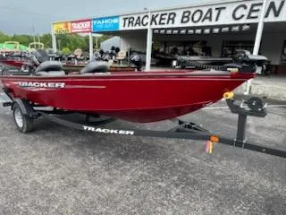 Slide: The Image of 2025 Tracker Super Guide V-16 T boat in red at dealership. - 2