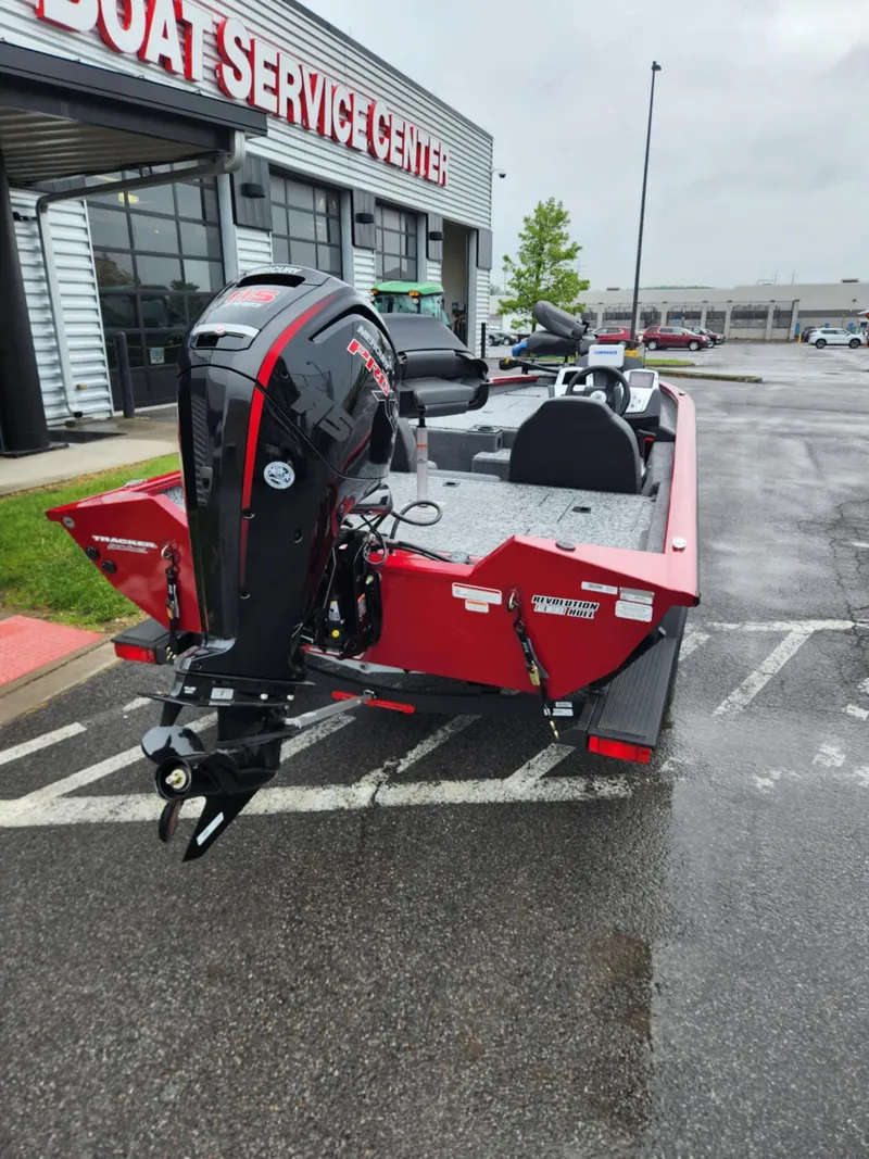 Slide: The Image of 2025 Tracker Pro Team 190 boat parked outside a service center on a rainy day. - 3