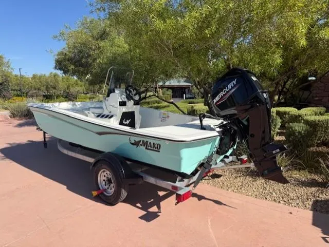 Slide: The Image of 2025 Mako Pro Skiff 15 CC boat on trailer with Mercury outboard motor. - 2