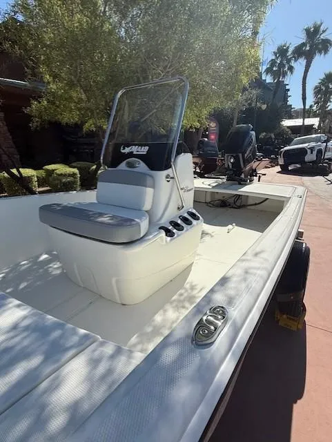 Slide: The Image of 2025 Mako Pro Skiff 15 CC boat with center console, parked outdoors in sunny setting. - 5