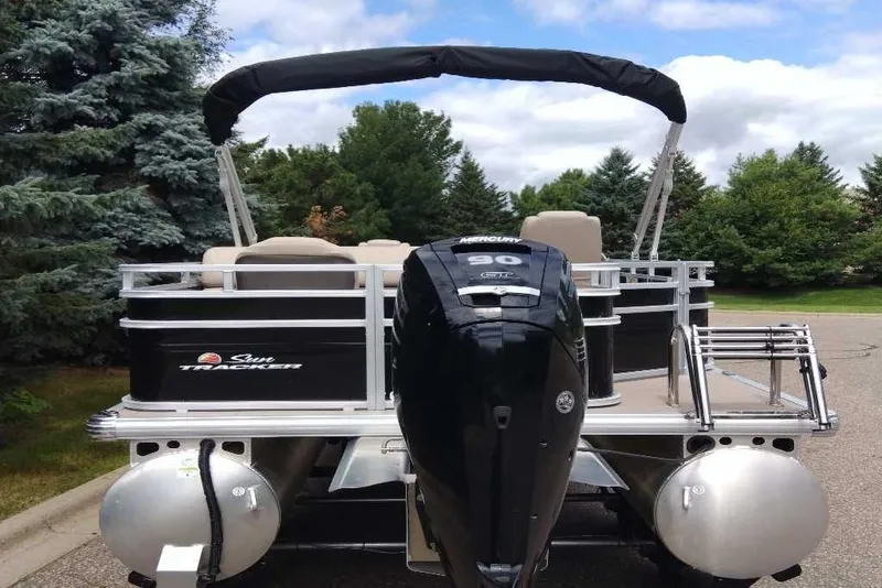 Slide: The Image of 2025 Sun Tracker SportFish 20 DLX pontoon boat with Mercury 90 engine, parked outdoors. - 5