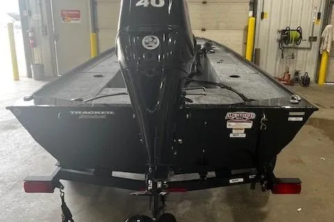 Slide: The Image of 2025 Tracker Panfish 17 boat in a garage, rear view with motor. - 3