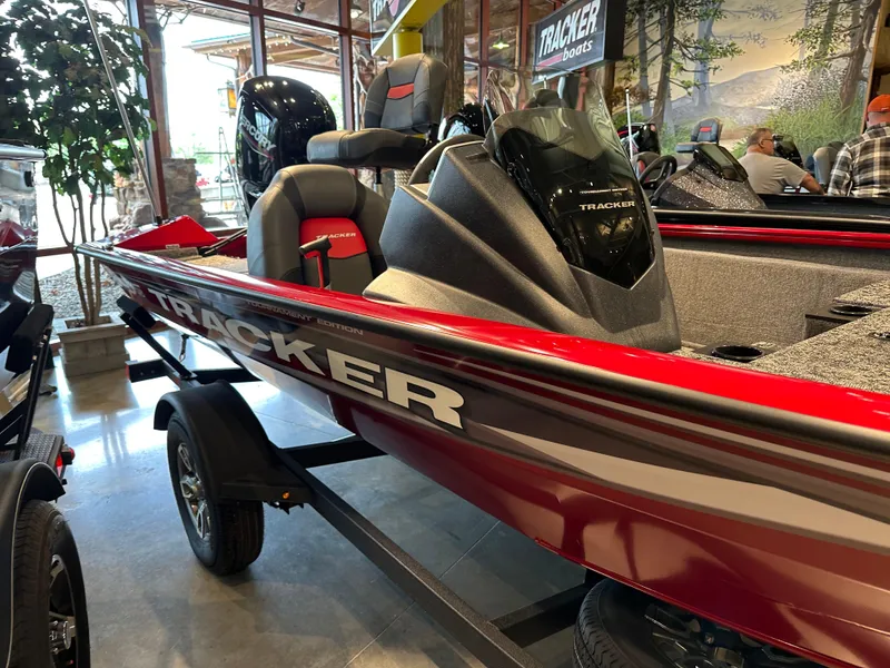 Slide: The Image of 2025 Tracker Pro Team 175 boat, red and gray, displayed indoors on a trailer. - 2
