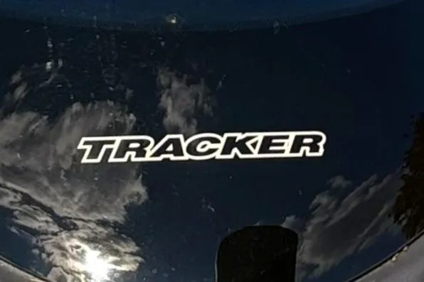 Slide: The Image of Tracker Pro 170 logo on reflective surface, 2025 model, with cloudy sky reflection. - 74