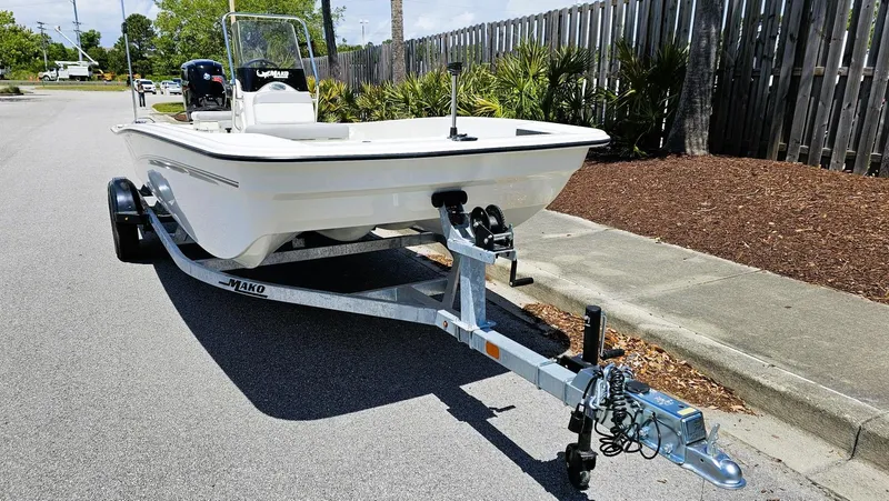 Slide: The Image of 2025 Mako Pro Skiff 17 CC boat on trailer, parked on a sunny street. - 10