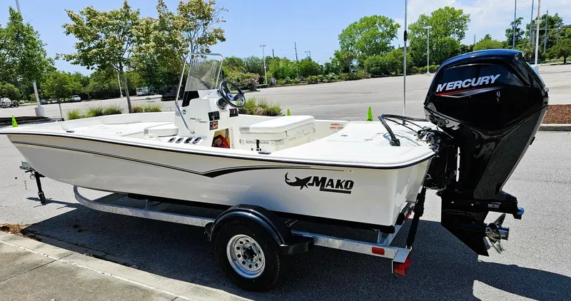 Slide: The Image of 2025 Mako Pro Skiff 17 CC boat with Mercury engine on trailer in parking lot. - 7
