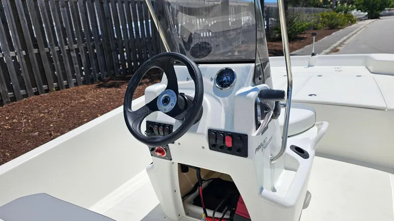 Slide: The Image of 2025 Mako Pro Skiff 17 CC boat console with steering wheel and controls. - 9
