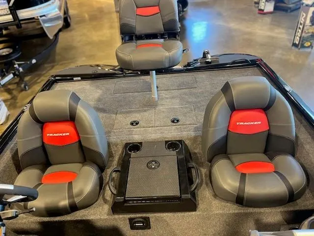 Slide: The Image of 2025 Tracker Savage 215 boat interior with gray and red seating, cup holders, and storage. - 7