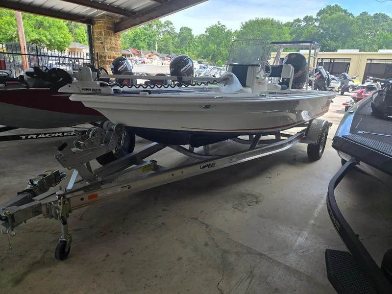 The Image of 2025 Mako 18 Pro Skiff Patriot Edition on trailer in covered storage area. - 0