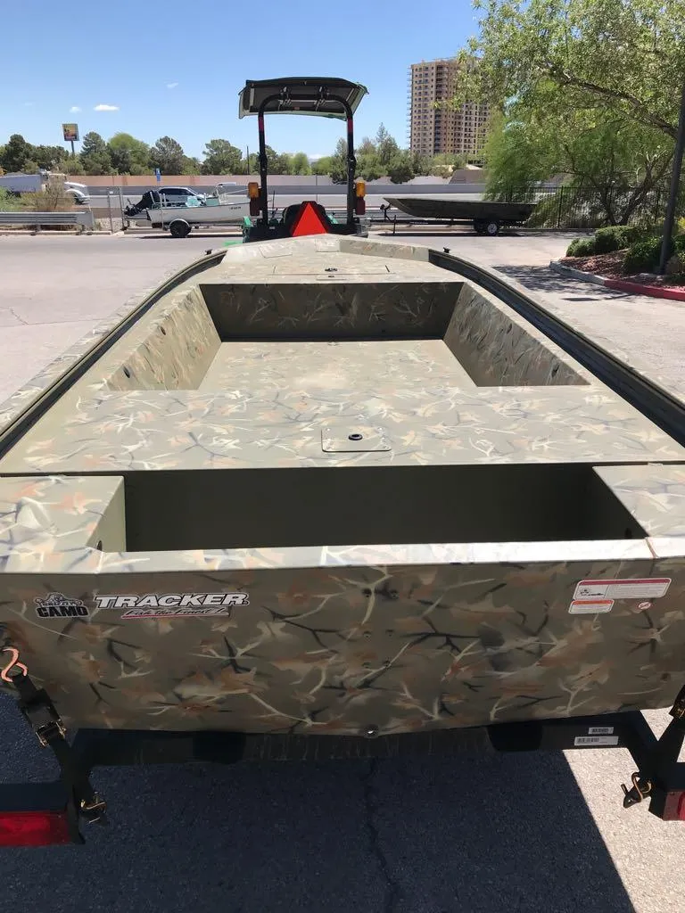 Slide: The Image of 2025 Tracker Grizzly 1648 Jon boat with camouflage design on a trailer. - 2