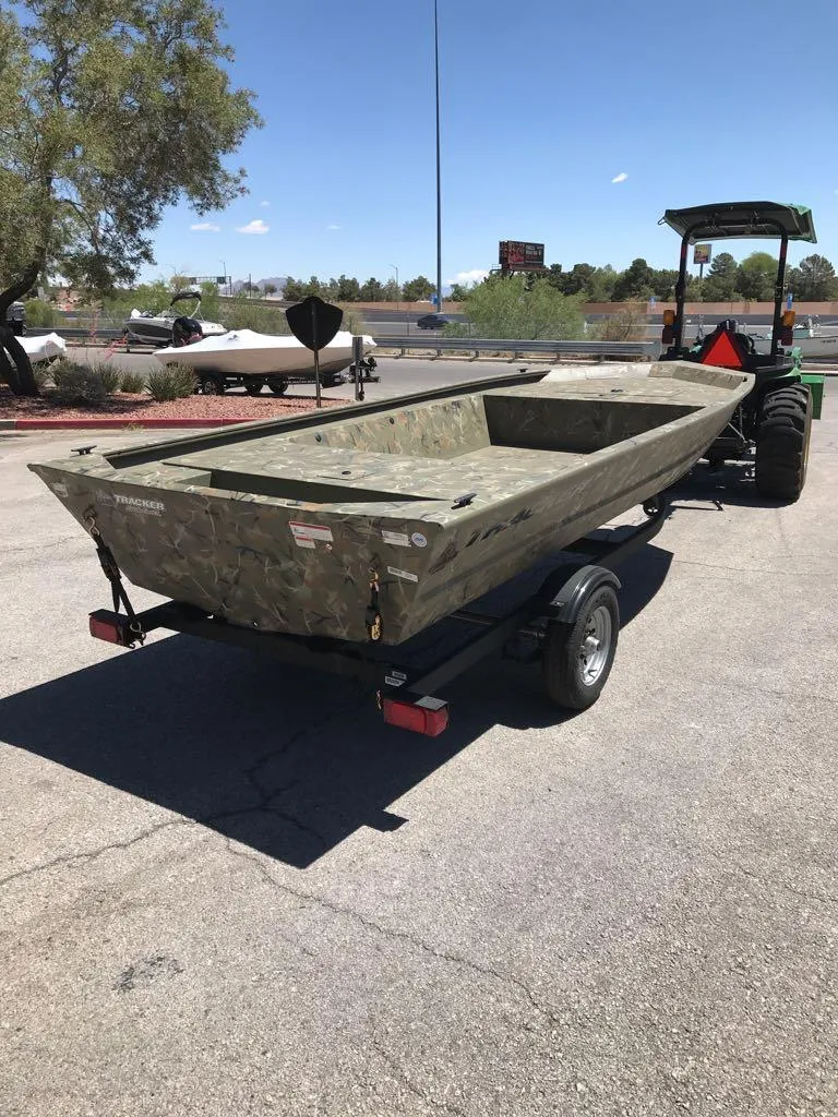 Slide: The Image of 2025 Tracker Grizzly 1648 Jon boat on trailer, parked outdoors under clear sky. - 3