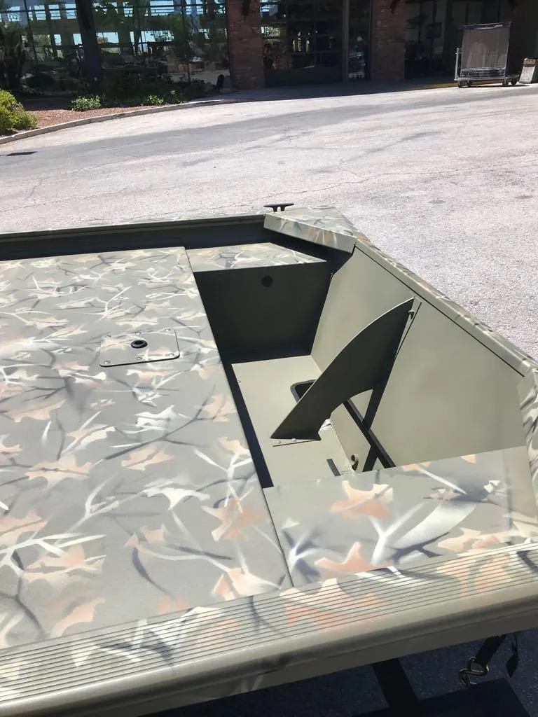 Slide: The Image of 2025 Tracker Grizzly 1648 Jon boat with camouflage design, docked outdoors. - 7