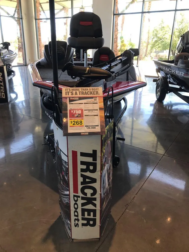 Slide: The Image of 2025 Tracker Pro Team 175 boat displayed in showroom with promotional signage. - 2