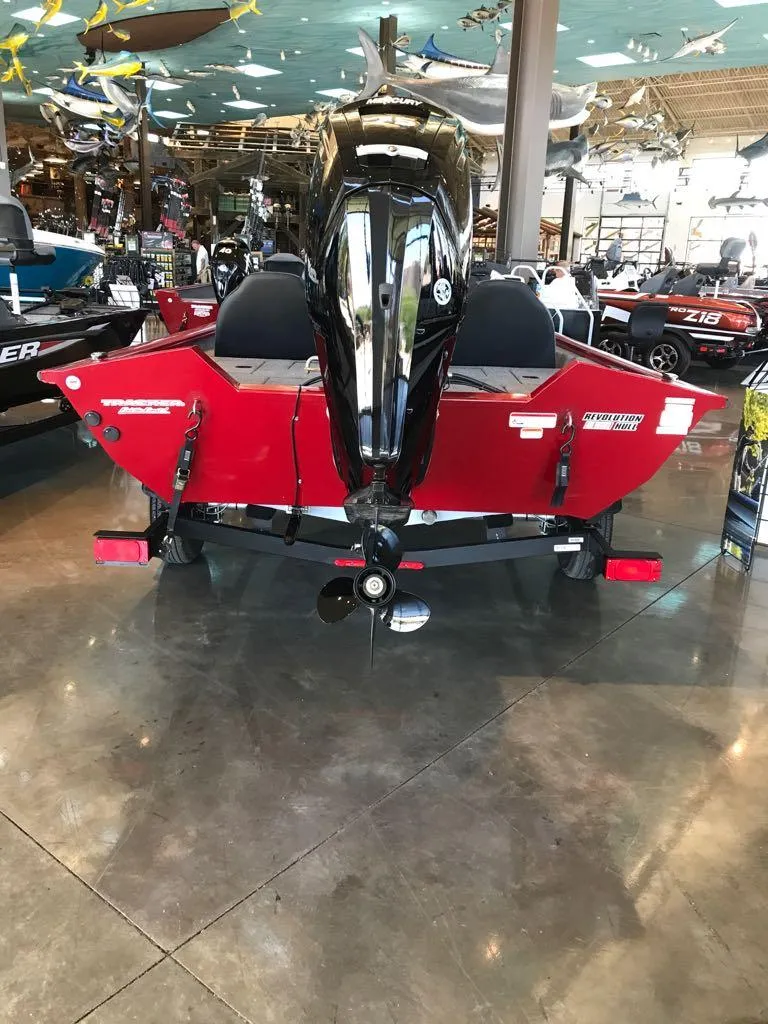 Slide: The Image of 2025 Tracker Pro Team 175 boat, red exterior, displayed indoors with motor visible. - 3