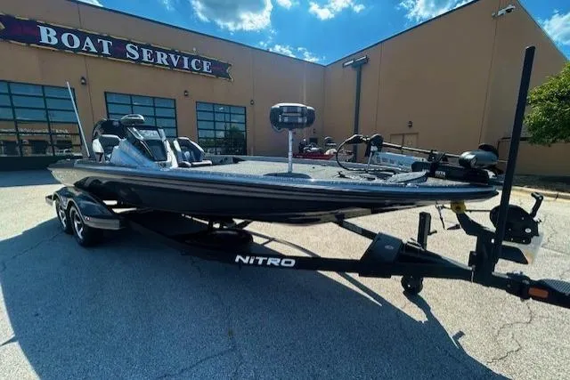 Slide: The Image of 2025 Nitro Z21 XL bass boat on trailer in parking lot. - 0