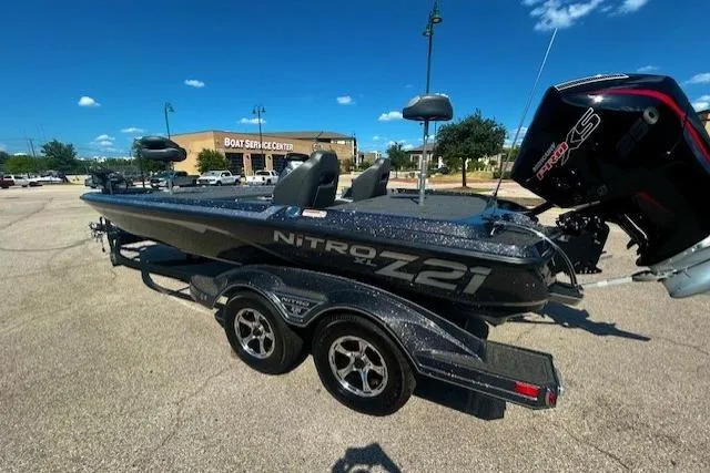 Slide: The Image of 2025 Nitro Z21 XL bass boat parked on asphalt under clear blue sky. - 3