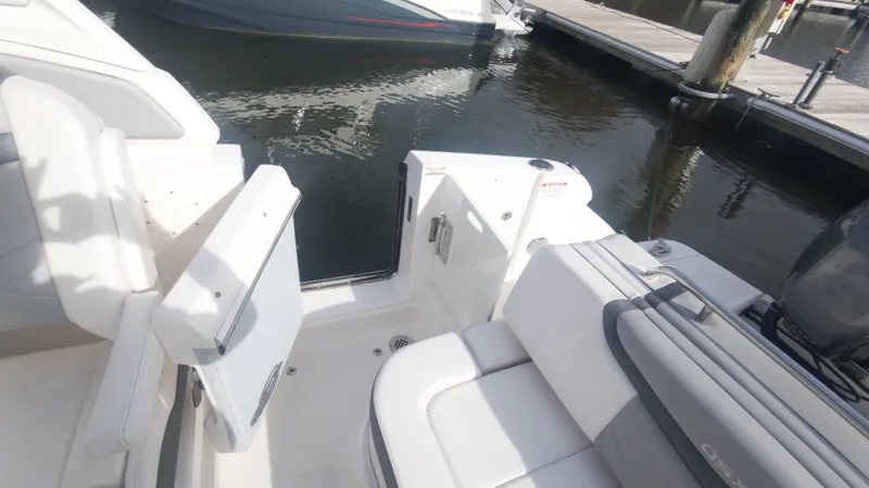 Slide: The Image of 2020 Chaparral 280 OSX boat interior with white seating at a marina. - 17