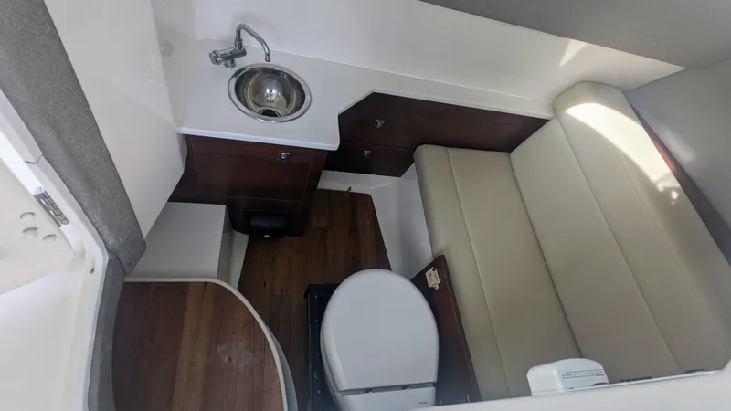 Slide: The Image of 2020 Chaparral 280 OSX boat interior with sink, toilet, and seating area. - 18