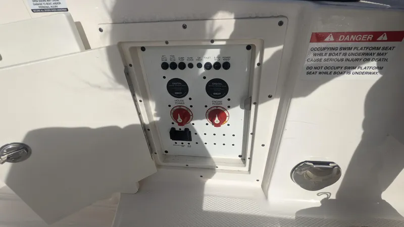 Slide: The Image of Control panel on a 2020 Chaparral 280 OSX boat, featuring switches and warning labels. - 19