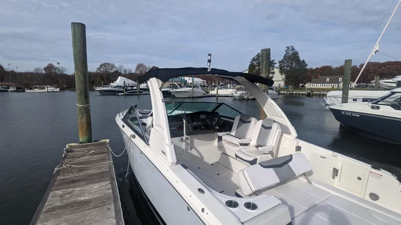 Slide: The Image of 2020 Chaparral 280 OSX boat docked at marina, featuring sleek design and spacious seating. - 2