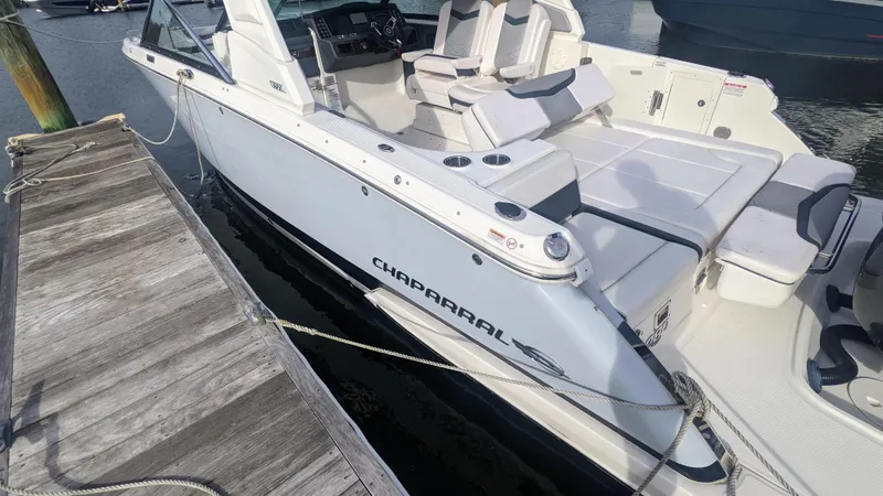 Slide: The Image of 2020 Chaparral 280 OSX boat docked, showcasing sleek design and spacious seating. - 3