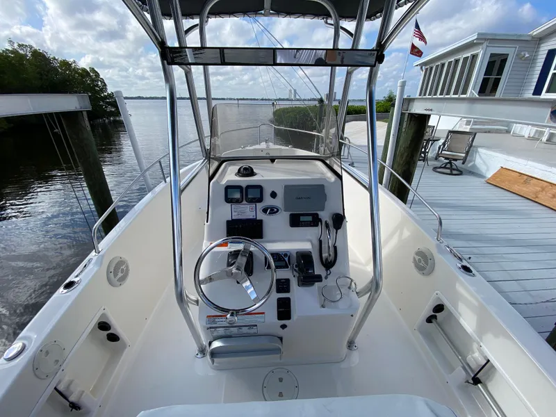 Slide: The Image of 2011 Pursuit C 200 Center Console boat docked by a waterfront deck. - 14