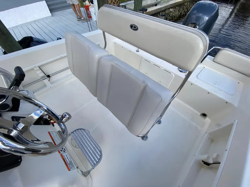 Slide: The Image of 2011 Pursuit C 200 Center Console boat interior with white seating and steering wheel. - 18