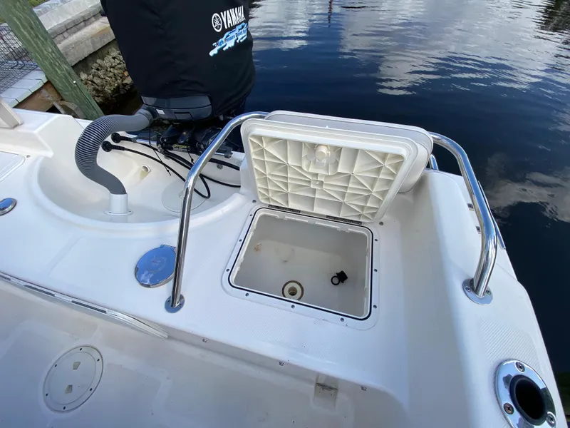 Slide: The Image of 2011 Pursuit C 200 Center Console boat with open storage compartment near water. - 20