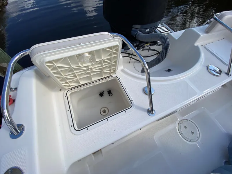 Slide: The Image of 2011 Pursuit C 200 Center Console boat with open storage compartment and railing. - 21