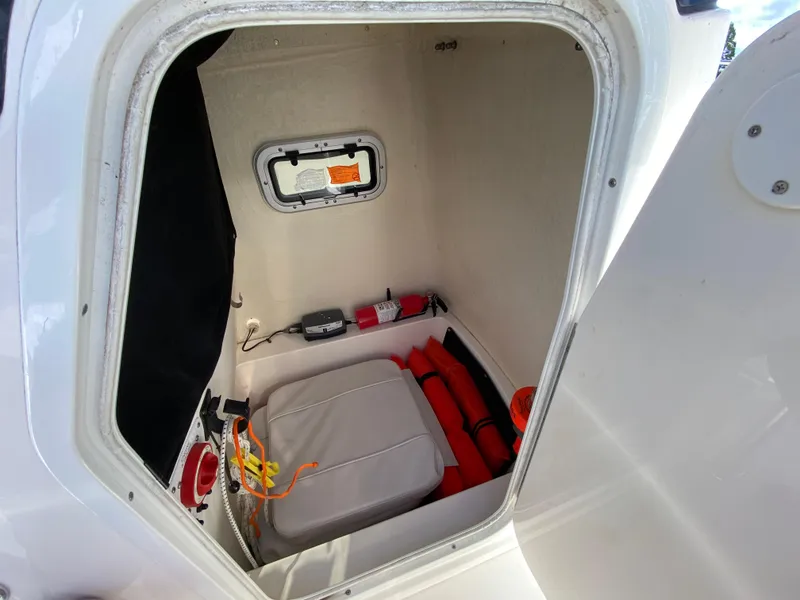 Slide: The Image of 2011 Pursuit C 200 Center Console storage compartment with safety equipment and fire extinguisher. - 27