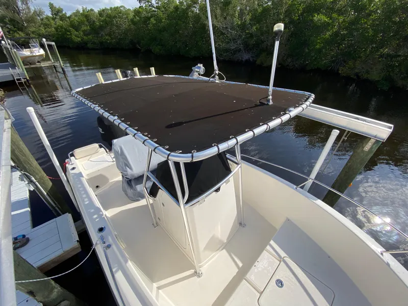 Slide: The Image of 2011 Pursuit C 200 Center Console boat docked by lush greenery. - 3