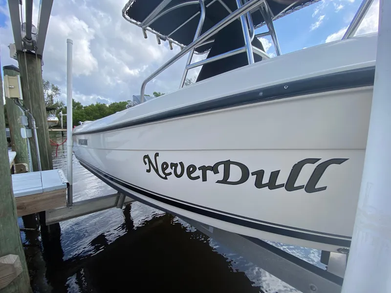 Slide: The Image of 2011 Pursuit C 200 Center Console boat named "Never Dull" docked by the water. - 43