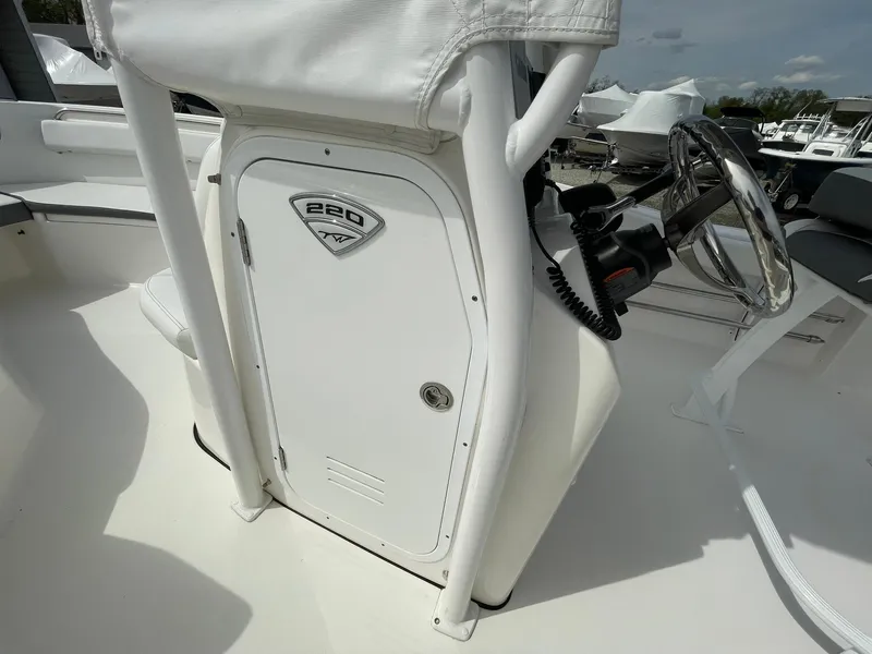 Slide: The Image of 2019 Tidewater 220 CC Adventure boat console with steering wheel and storage compartment. - 19