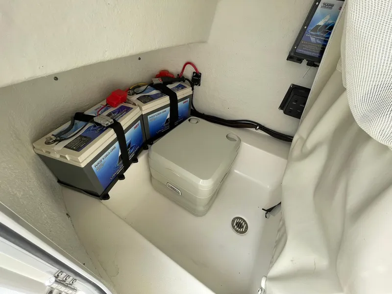 Slide: The Image of 2019 Tidewater 220 CC Adventure boat interior with batteries and portable toilet. - 20