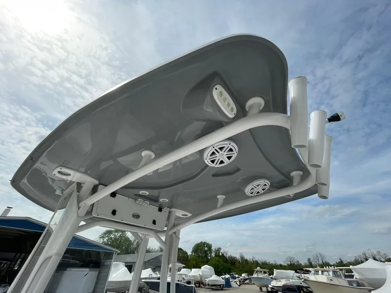 Slide: The Image of Tidewater 220 CC Adventure 2019 boat's T-top with speakers and rod holders under a cloudy sky. - 29