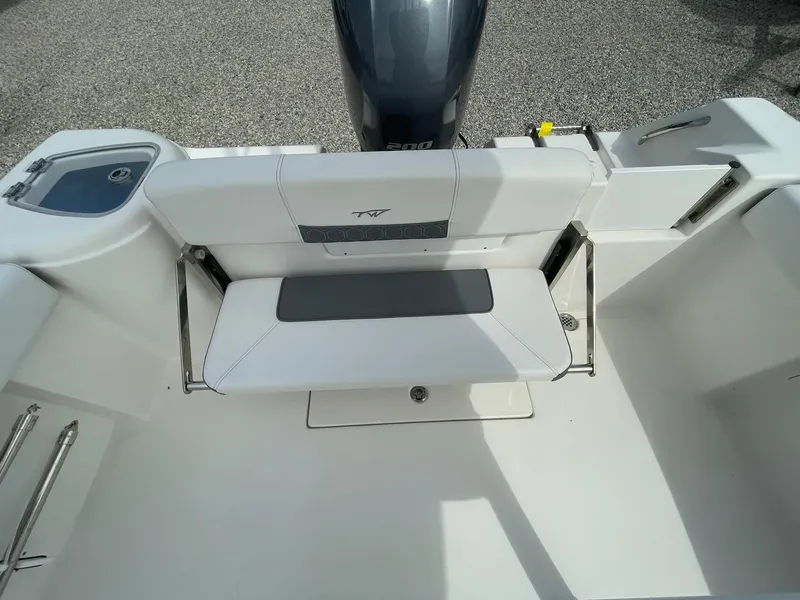 Slide: The Image of 2019 Tidewater 220 CC Adventure boat interior with foldable seating and motor view. - 33