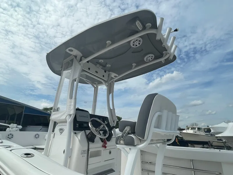 Slide: The Image of 2019 Tidewater 220 CC Adventure boat with T-top and helm, under a partly cloudy sky. - 4
