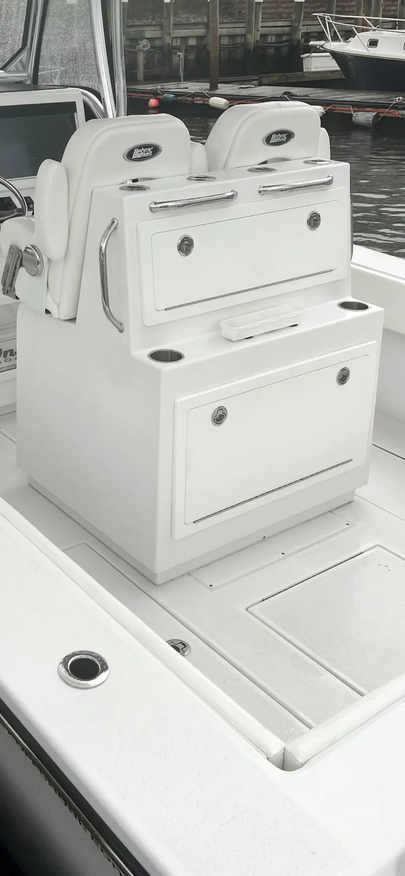 Slide: The Image of 2023 Onslow Bay 27 Offshore boat interior with white seating and storage compartments. - 11