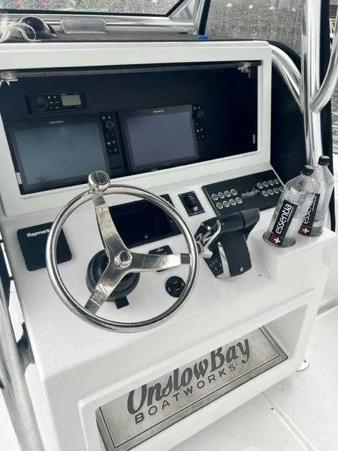 Slide: The Image of 2023 Onslow Bay 27 Offshore boat dashboard with steering wheel and navigation controls. - 12