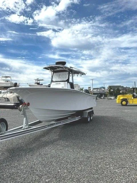 Slide: The Image of 2023 Onslow Bay 27 Offshore boat on trailer under a partly cloudy sky. - 2